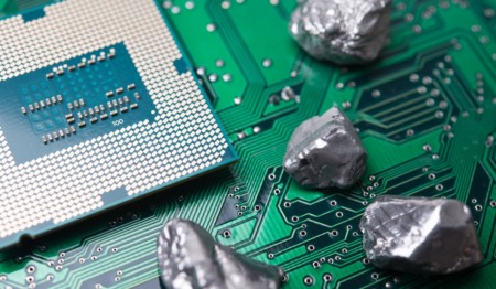 Processador de computador sobre uma placa de circuito verde, acompanhado por quatro pepitas metálicas prateadas que representam minerais críticos Processador de computador sobre uma placa de circuito verde, acompanhado por quatro pepitas metálicas prateadas que representam minerais críticos