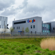 Imagem de uma instala&ccedil;&atilde;o de data center com o logo do Google, e grama na frente