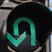 Close de uma seta verde em um sem&aacute;foro permitindo o retorno