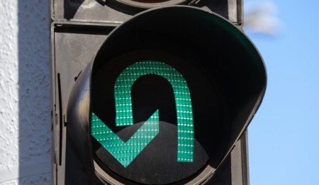 Close de uma seta verde em um semáforo permitindo o retorno Close de uma seta verde em um semáforo permitindo o retorno