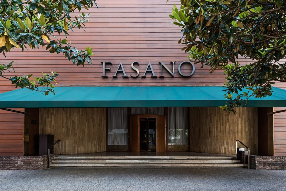 Foto da fachada do hotel Fasano em São Paulo, com o nome na frente, um toldo verde e árvores Foto da fachada do hotel Fasano em São Paulo, com o nome na frente, um toldo verde e árvores