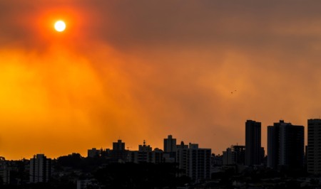 Horizonte de uma cidade com prédios. O céu está poluído e laranja Horizonte de uma cidade com prédios. O céu está poluído e laranja