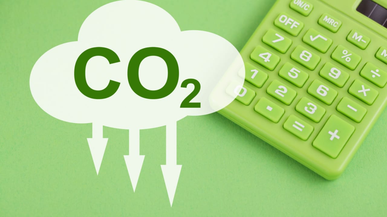 calculadora verde sob fundo verde com símbolo de co2 indicando redução